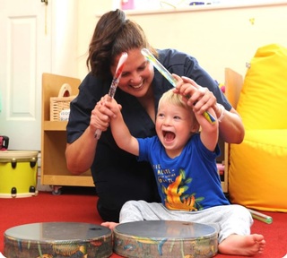 Nursery worker and child make music. Credit: Rainbow Hub