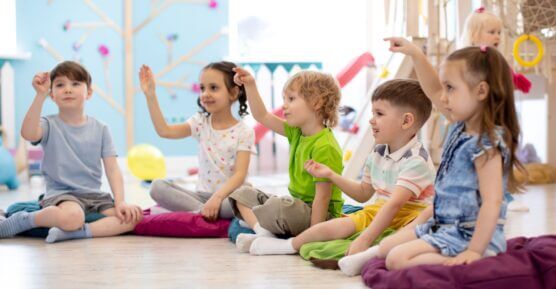 Children playing a game with hand actions in a nursery